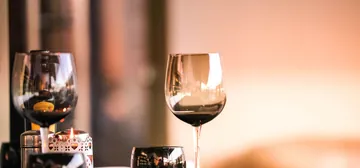 Two glasses of wine on a restaurant table in warm light